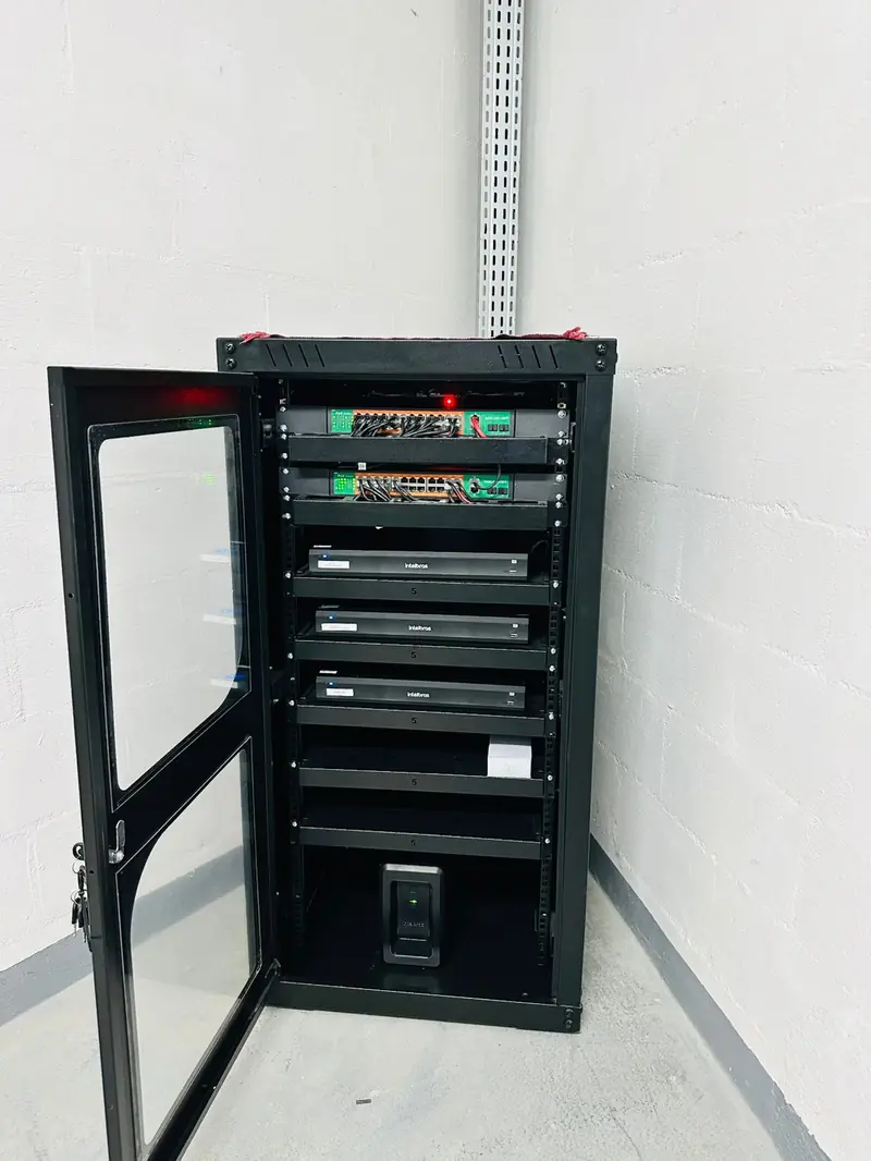 Rack 19 polegadas com porta de vidro aberta, switches PoE e três gravadores Intelbras