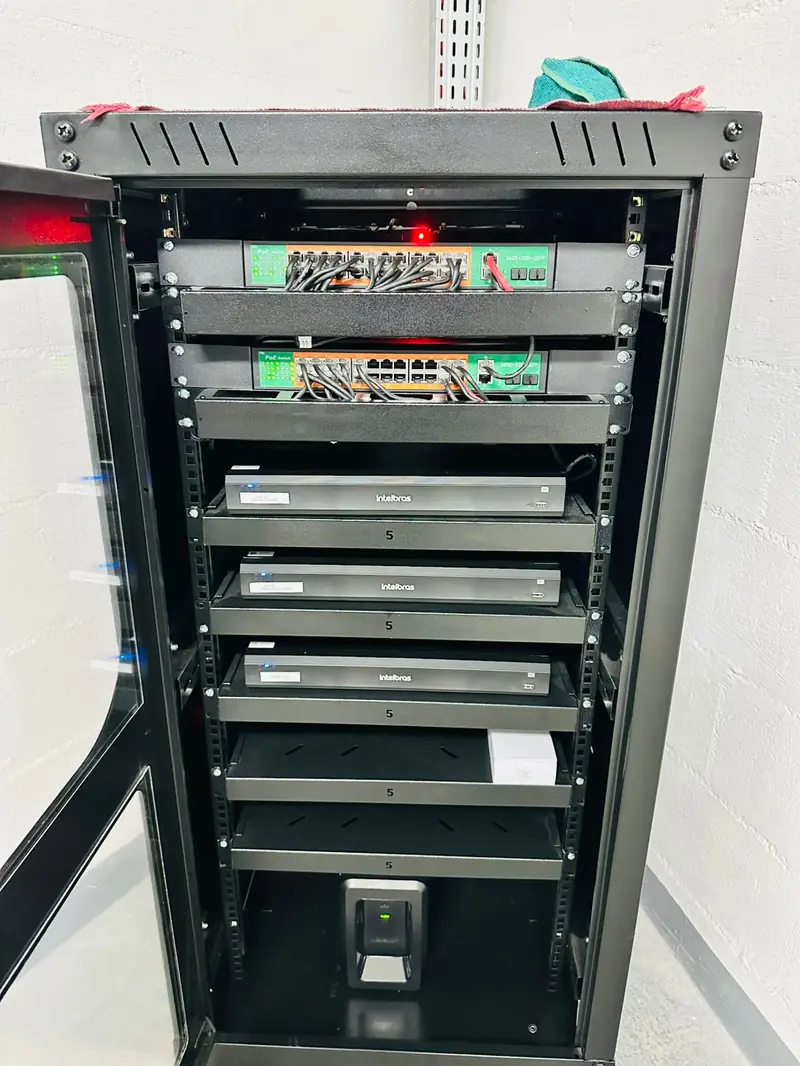 Rack com três gravadores DVR Intelbras e dois switches PoE